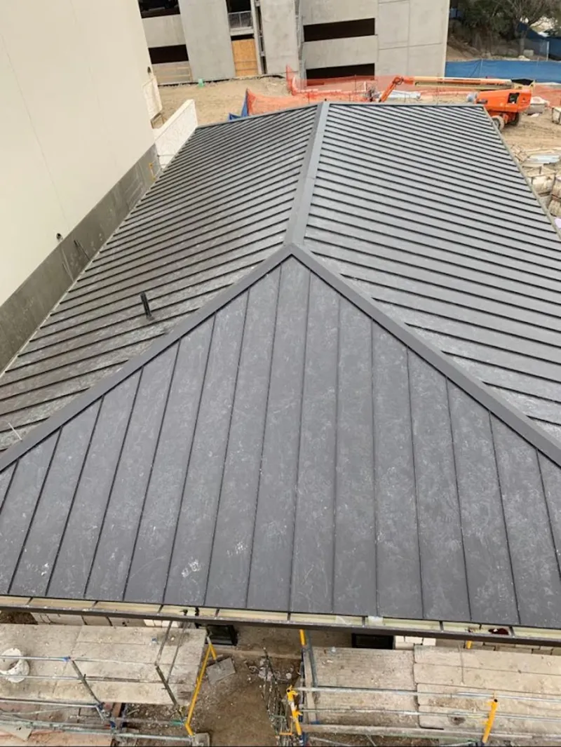 Commercial metal roof construction with crane equipment in St. Peter